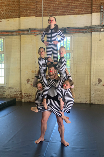 Children in circus pose with Circa acrobat